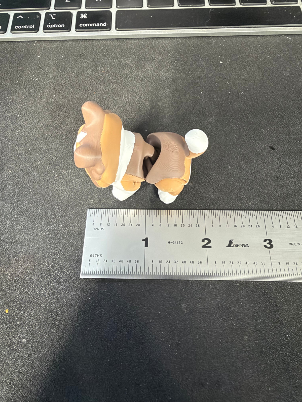 Top view of Sheltie fidget beside an inch ruler for size reference.